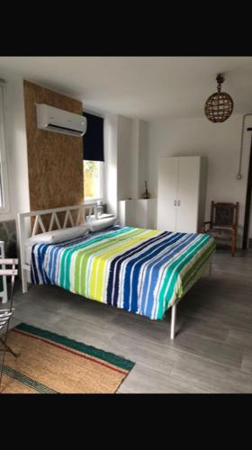 a bedroom with a bed with a colorful striped blanket at La Casa di Manu in Lessona