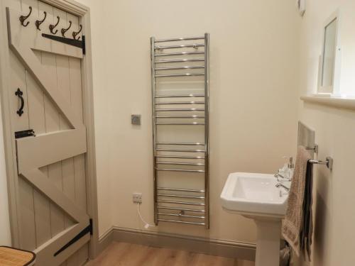 a bathroom with a sink next to a door at Cragg Lodge in Hexham