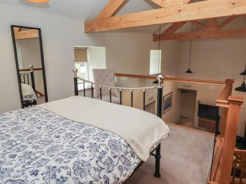 a bedroom with a bed with a blue and white blanket at Cragg Lodge in Hexham