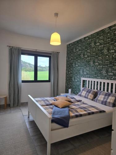 a bedroom with a bed and a brick wall at Quinta Velha in Ribeira Grande