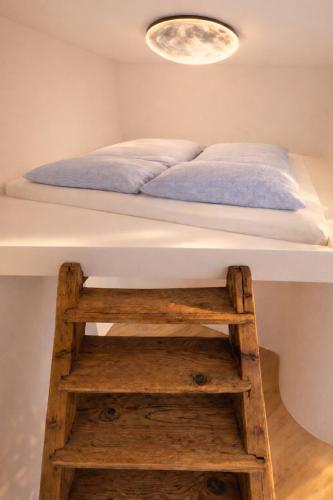 a bedroom with a bed and a wooden ladder at Boutique Loft Studio in Kreuzlingen