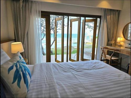 a bedroom with a bed with a view of the ocean at Villa Baan Loukpla in Hua Hin