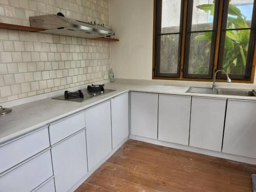 a kitchen with white cabinets and a sink at Villa Baan Loukpla in Hua Hin