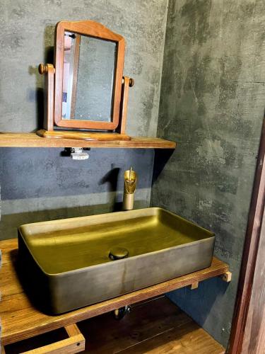 a bathroom with a green sink and a mirror at Maison N in Shimoda