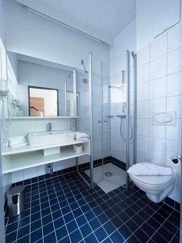 a bathroom with a sink and a toilet and a shower at Hotel Grazerhof in Bad Gleichenberg
