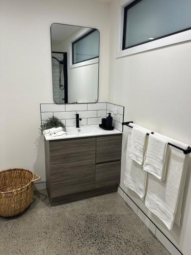 a bathroom with a sink and a mirror at Modern Soho Pad with Sunny Deck in West Hobart