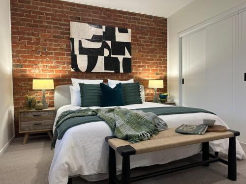 a bedroom with a bed and a brick wall at Modern Soho Pad with Sunny Deck in West Hobart