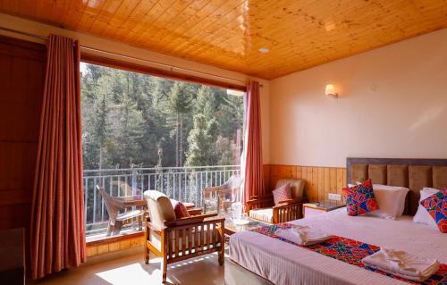 a bedroom with two beds and a large window at The Himvan Stay in Mundaghat 