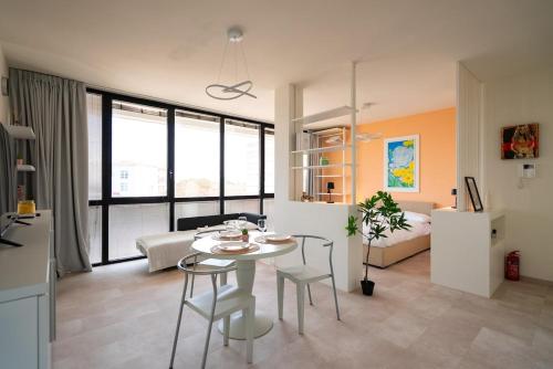 a living room with a table and a bedroom at Attico Belvedere Randi in Ravenna