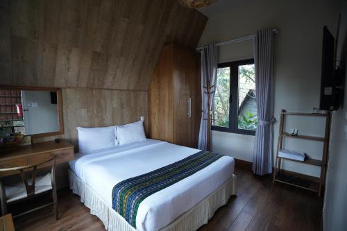 a bedroom with a bed and a desk and a window at TTC Dreamy Hill Resort - Unlimited Access to TTC World - Thung Lung Tinh Yeu in Da Lat