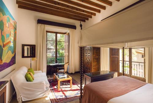 a bedroom with a bed and a living room at La Residencia, A Belmond Hotel, Mallorca in Deia