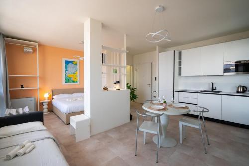 a kitchen and a living room with a bed and a table at Attico Belvedere Randi in Ravenna