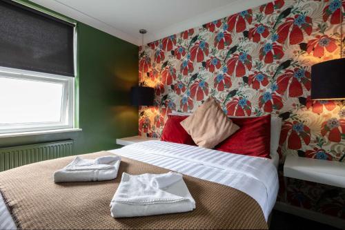 a bedroom with a bed with towels on it at Old Ship Inn Hackney in London