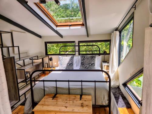 a bedroom in a tiny house with a bed and windows at ZenCapeTown Forest Retreat in Cape Town
