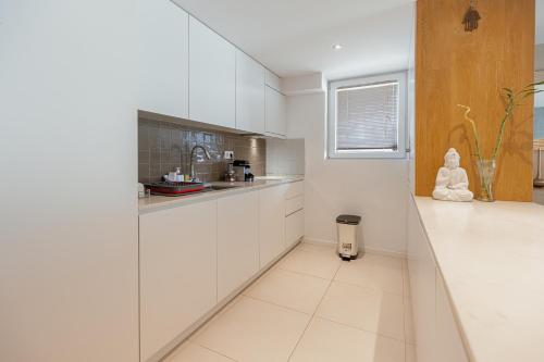 a kitchen with white cabinets and a counter top at Luxury Beach House by Hosty in Canidelo