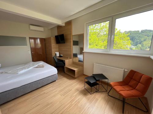 a bedroom with a bed and a chair and a desk at Hotel Grazerhof in Bad Gleichenberg
