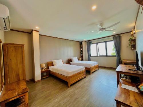 a bedroom with two beds and a ceiling fan at Ancarine Beach Resort in Phú Quốc