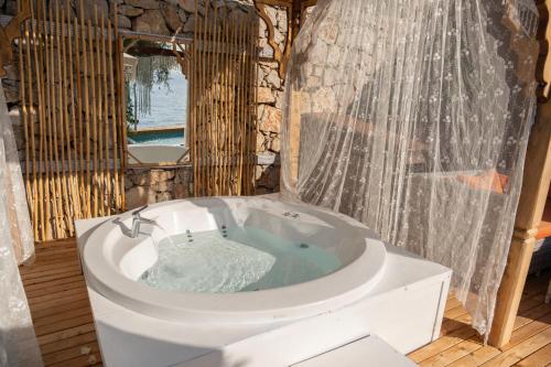 a bathroom with a bath tub with a shower at Zakros Hotel Lykia in Faralya
