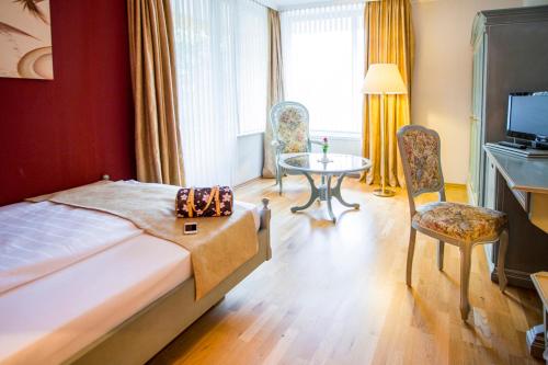a hotel room with a bed and a table and chairs at Gästehaus Maasberg in Bad Sobernheim