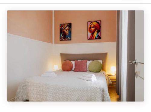 a bedroom with a bed with four pictures on the wall at Appartamento la Speranza in Grosseto