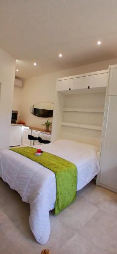 a bedroom with a large bed with a green blanket on it at Studio port santa lucia in Saint-Raphaël