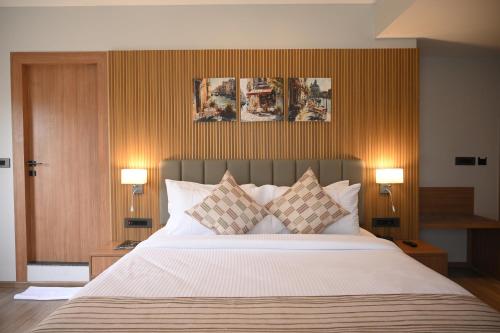 a bedroom with a large bed with pillows and two lamps at Brahmaputra Manor in Tezpur