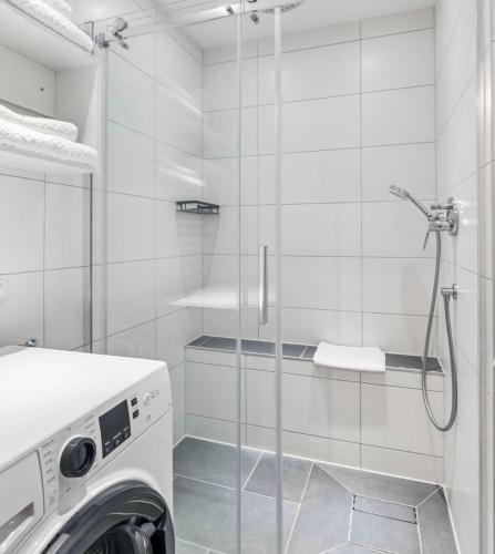 a bathroom with a washing machine and a glass shower at Prime Host perfect room in Karlsruhe