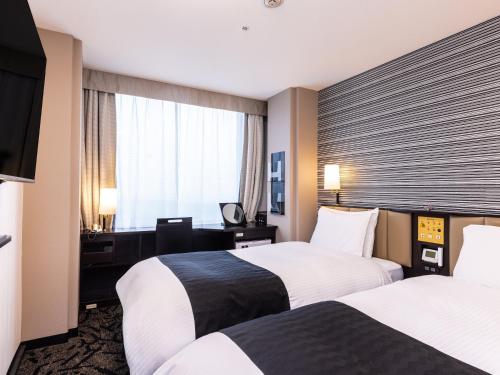 a hotel room with two beds and a window at APA Hotel & Resort Tokyo Bay Makuhari in Chiba