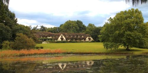 a large house on a field next to a lake at Rawdons Hotel & Brewery in Nottingham Road