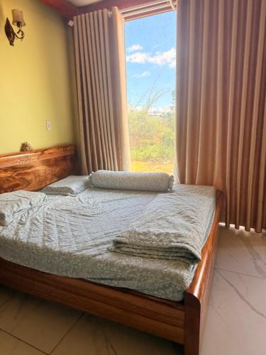 a bedroom with a bed with a large window at Líu homestay in Klong A