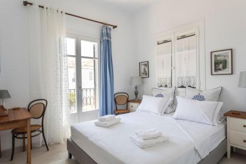 a bedroom with a white bed with towels on it at Eagle House Spetses 4 bedrooms in Spetses