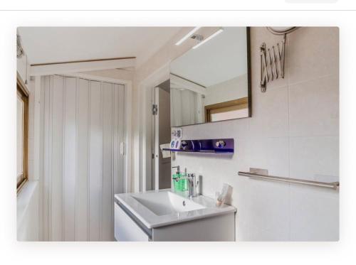 a white bathroom with a sink and a mirror at Appartamento la Speranza in Grosseto