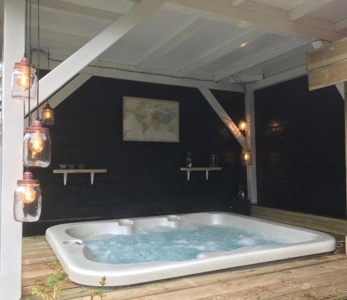 a bath tub with blue water in a room at Appartement met jacuzzi in Huizen in Huizen