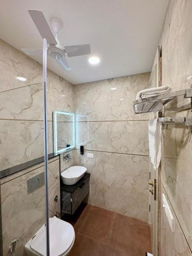 a bathroom with a toilet and a sink and a mirror at Hotel Starway in Hisār