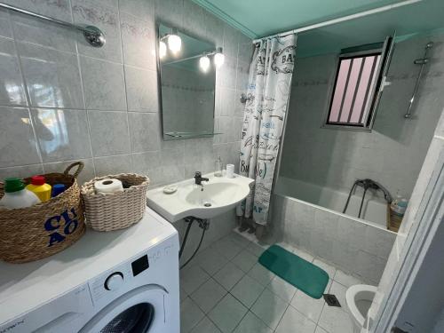 a bathroom with a washing machine and a sink at Bella's House in Theologos