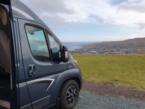 a blue van parked on the side of a hill at Adventure Campervan to Explore the Faroes in Hoyvík