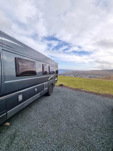 a silver caravan parked on the side of a road at Adventure Campervan to Explore the Faroes in Hoyvík