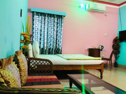a room with a bed and a couch and a table at Green View Resthouse in Sreemangal