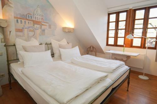 two white beds in a room with a painting on the wall at Hotel Stadtherz in Burgwedel