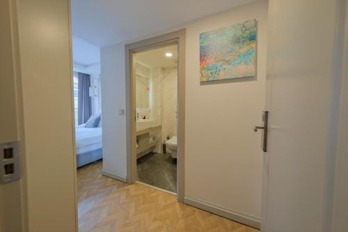 une salle de bains avec un miroir et une chambre avec un lit dans l'établissement Serai Hotel, à Istanbul