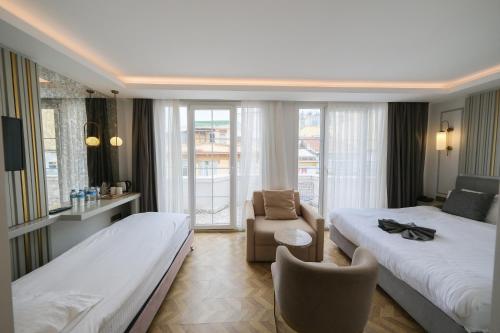 une chambre d'hôtel avec deux lits et une chaise dans l'établissement Serai Hotel, à Istanbul