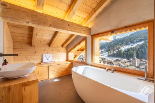 a bathroom with a tub and a sink and a window at Chalet BO'M in Le Grand-Bornand