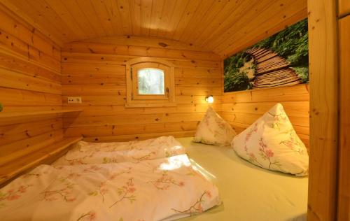 a bedroom with a bed in a wooden cabin at NATURAMA Brombachsee Schäferwagenhotel in Pleinfeld