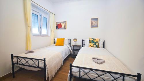two beds in a room with a window at Cascais Garden House 103 in Cascais