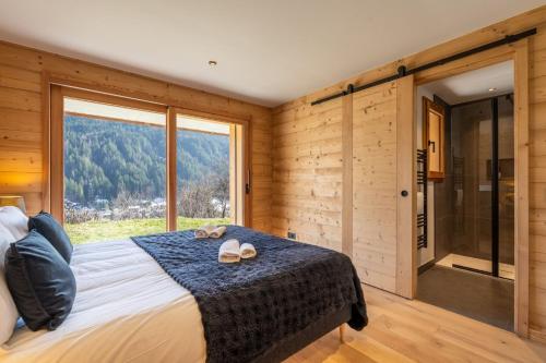 a bedroom with a bed and a large window at Chalet BO'M in Le Grand-Bornand
