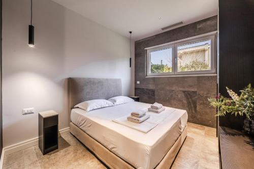 a bedroom with a bed and a window at Villa AMMA Pool & Jacuzzi by PikHost in Draç