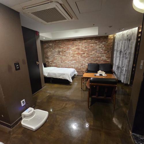 a room with a bed and a table and chairs at Christie Hotel 크리스티 호텔 in Seoul