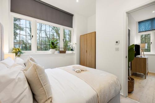 a bedroom with a white bed and windows at Modern 2 Bed Apartment by MCF in Merstham