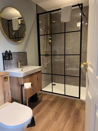 a bathroom with a shower and a sink and a toilet at The Braeriach in Newtonmore