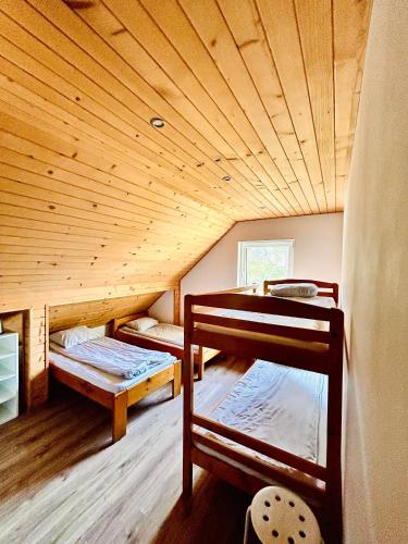 two bunk beds in a room with a wooden ceiling at Pokoje Gościnne Dunajec in Zabrzeź